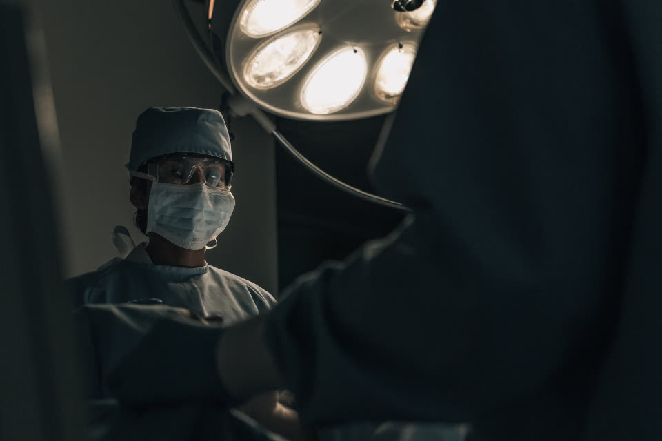 Surgeon under theatre lights in a hospital operating room